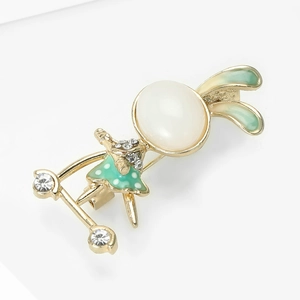 Close-up of cute rabbit scooter brooch with enamel details and sparkling rhinestones