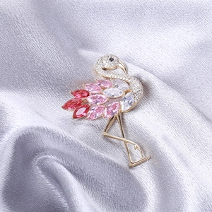Funkelnde Flamingo Brosche mit Farbverlauf Zirkonia und Vergoldung auf grauer Seide