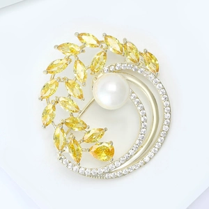 Détail de la broche fleur avec zircons marquises jaunes et une grande perle blanche