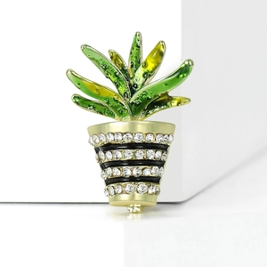 Close-up of cactus plant brooch with green enamel leaves and rhinestone-studded flowerpot