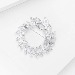 Makrodetail der silbernen Blattkranz-Brosche mit funkelnden Marquise-Kristallsteinen