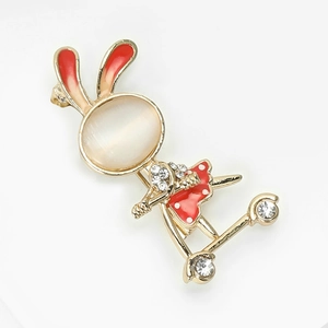 Close-up of rabbit brooch with white opal head and red enamel dress details