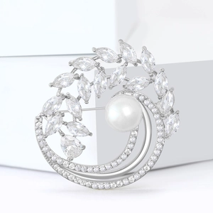 Broche perle et feuille d'olivier en argent avec zircons sur présentoir à bijoux