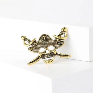 Detailed macro view of vintage gold pirate skull and cross swords brooch with aged texture