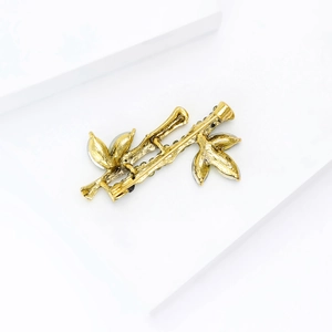 Detailed back view of golden bamboo brooch showing secure pin clasp and metal texture