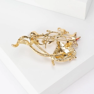 Gouden koralen broche met zeester en schelphangers op een witte achtergrond