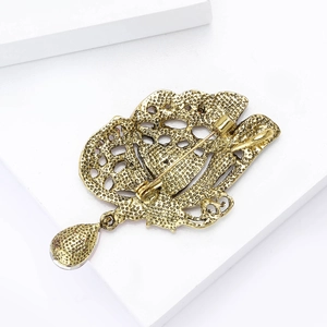 Détail macro du dos d'une broche papillon vintage avec fermoir à épingle et pendentif goutte