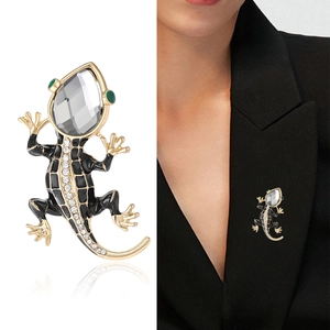 Lizard brooch with black enamel and grey gemstone on a suit jacket lapel