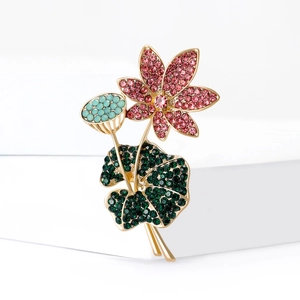 Elegante lotusbloem broche met roze bloem en groene kristallen op gouden basis