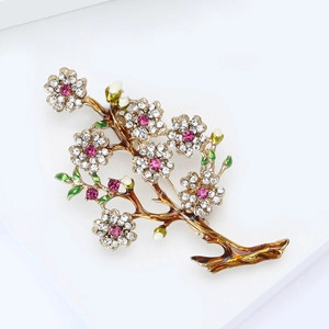 Elegant floral brooch with pink rhinestones and enamel leaves on a gold branch