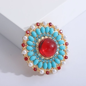 Baroque style antique brooch with red gemstone and blue crystals in vintage gold finish