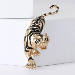 Vintage gold-toned tiger brooch with black enamel stripes on a minimalist white background