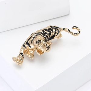 Golden alloy tiger brooch with black enamel details on a minimalist white display