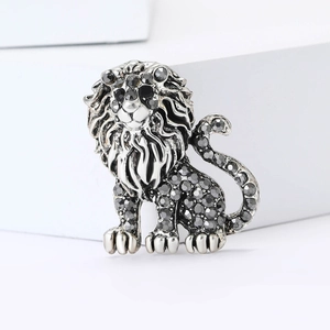 Vintage silver lion brooch with grey crystals on a geometric white display base