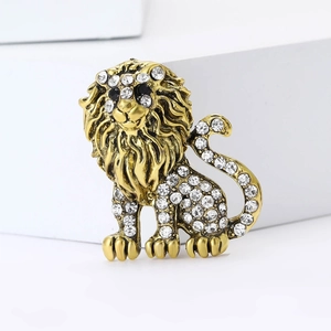 Vintage gold lion brooch with white rhinestones on a white pedestal stand