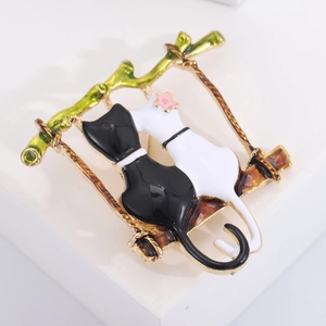 Détail d'une broche chat en émail sur une balançoire en bambou vert, fini poli
