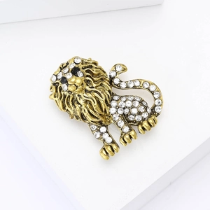 Close-up detail of vintage lion brooch with white crystals and golden finish
