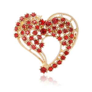 Spilla a cuore dorata elegante con strass rossi e design traforato su bianco