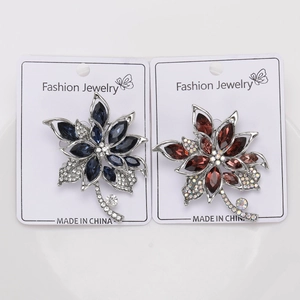 Detail of floral crystal brooches in navy blue and burgundy with silver alloy base