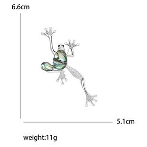 Retro frog brooch with abalone shell inlay and rhinestones on a white background