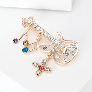 Broche guitare dorée avec strass scintillants et pendentifs en forme de notes de musique