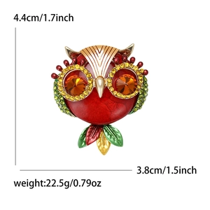 Vintage owl brooch in red enamel with green crystals and orange gemstone details