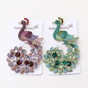 Detailed macro view of vintage peacock brooches with colorful crystals and alloy inlay