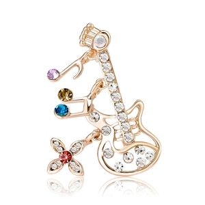 Broche guitare évidée avec strass colorés et pendentifs notes de musique en or