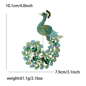 Exquisite peacock brooch with green rhinestones and crystals on white background
