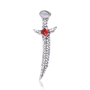 Macro detail of silver dagger brooch with white opal stone and red zircon crystals