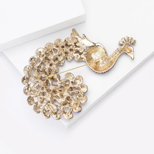 Golden peacock animal brooch with crystal accents and detailed hollow feather pattern