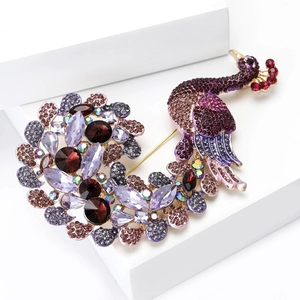 Macro detail of a golden peacock brooch encrusted with deep purple and red crystals
