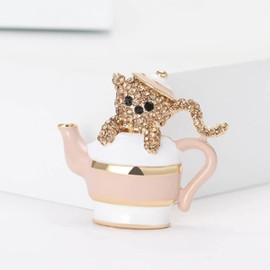Broche chat en émail dans une théière avec strass champagne sur un bloc géométrique