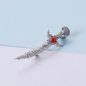 Detailed macro view of silver dagger brooch with sparkling rhinestones and red gemstone
