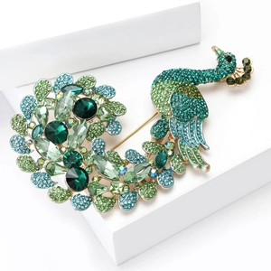 Detailed macro view of peacock brooch with sparkling green and blue crystals on golden base