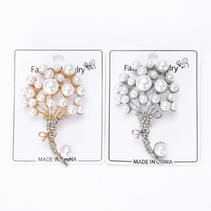 Dettaglio di eleganti spille a bouquet di perle con strass in finitura oro e argento