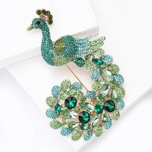 Exquisite peacock brooch with green and blue crystals on a golden metal base jewelry