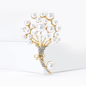 Elegante spilla bouquet di perle con fiocco dorato e strass su sfondo bianco puro