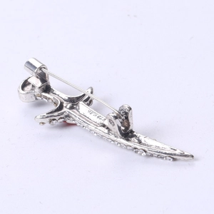 Detailed back view of silver dagger brooch with rhinestone inlay and safety pin closure