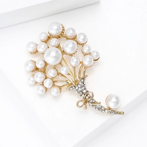 Dettaglio della spilla a bouquet di perle con finitura dorata e strass brillanti luminosi