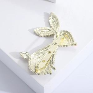 Detail view of the gold bunny brooch back featuring safety pin clasp and rhinestones