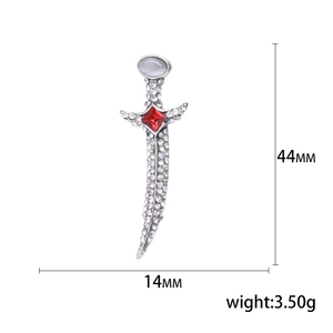 Sparkling silver dagger brooch with white crystals and a red square gemstone accent