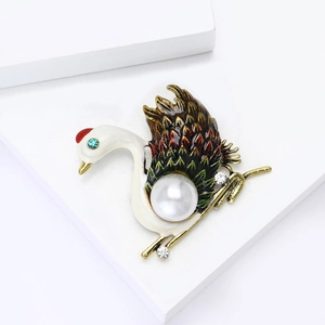 Elegant swan brooch with white enamel, large pearl, and colorful crystal accents on a white base