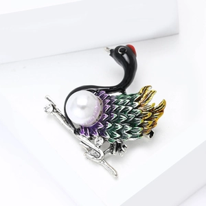 Detail showing colorful enamel swan brooch with large pearl and sparkling rhinestones
