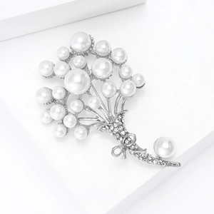 Dettaglio di una spilla a bouquet di perle argento con strass e fiocco elegante