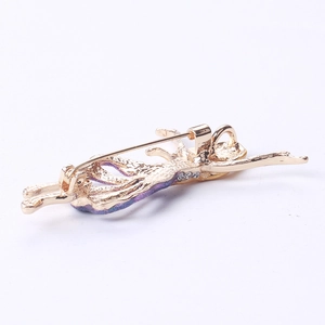 Macro detail of ballerina brooch showing gold alloy plating and safety pin fastening