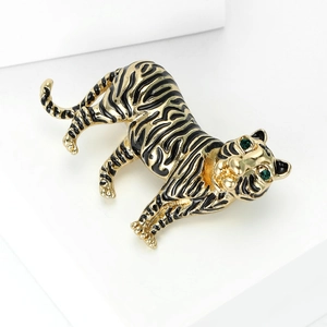 Macro detail of a vintage tiger brooch with golden plating and green gemstone eyes