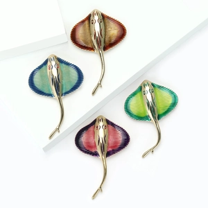 Set of four colorful enamel stingray brooches in gold finish on white props