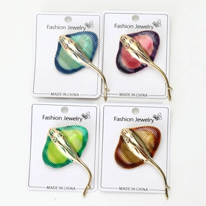 Detailed view of four colorful enamel stingray brooches with gold metal finish and pins