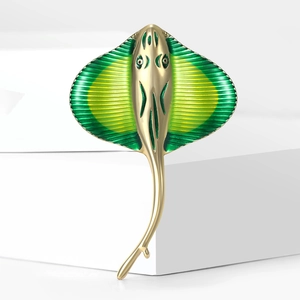 Macro shot of green enamel stingray brooch with textured golden metal finish